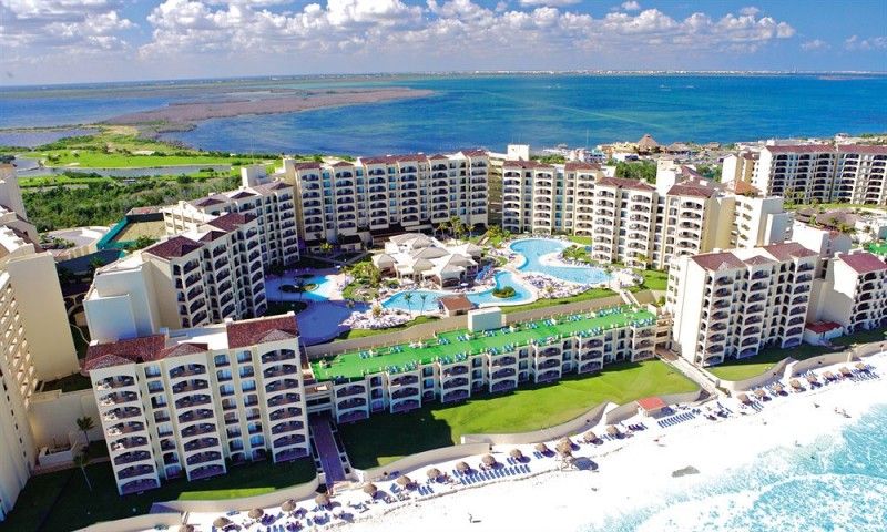 Hilton Cancun Mar Caribe - Coastal beachfront resort surrounded by tropical palm trees and lush landscaping.