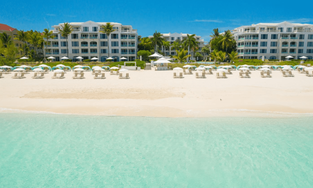 Exterior of The Palms resort highlighting its elegant colonial-inspired architecture, inviting pool, and lush tropical gardens